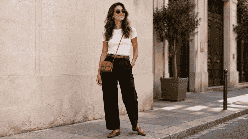 Woman in black linen pants with a white fitted top and loafers for a chic casual look