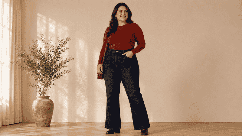 Curvy pear-shaped woman in high-rise bootcut jeans with a fitted top and block heel boots