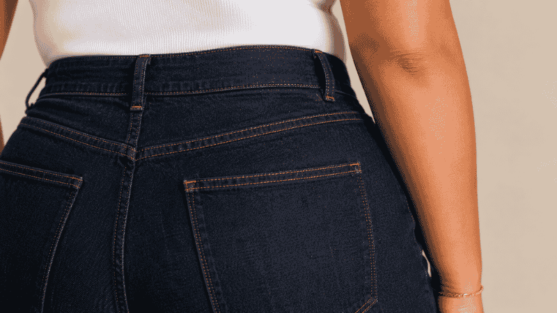 Close-up of a contoured no-gap waistband on curvy fit jeans showing smooth fit at the back waist